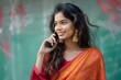 © movinglines.studio - Young indian Woman in Traditional Saree Talking on Phone with Bright Smile
