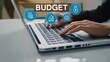 © Stocks Buddy - A person typing on laptop with budget icons floating above it showing financial budget concept
