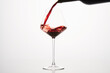 © Ilshat - Red wine is poured from bottle into transparent glass.