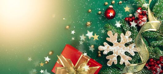 Wall Mural - christmas decorations concept. border of gifts, snowflakes, trinkets and fir branches on a green bac