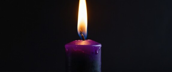 Sticker - a purple candle on plain black background for banner with copy space