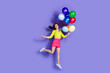 © deagreez - Photo of cheerful glad adorable lovely girl wear stylish clothes helium balloons isolated on purple color background