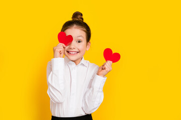 Poster - Photo of cute schoolgirl hold cover eye small heart empty space wear uniform isolated on yellow color background