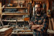© Elmira - A bearded carpenter stands confidently in his well-equipped workshop, his arms crossed as he looks directly at the camera