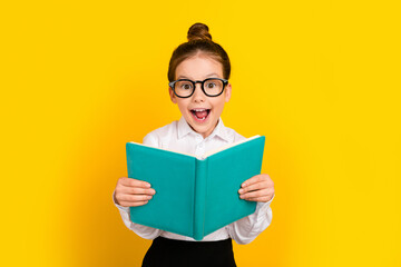 Wall Mural - Photo of cute schoolgirl hold opened book wear uniform isolated on yellow color background