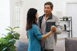 © itchaznong - Elderly Couple Dancing Together in a Cozy Living Room with Natural Light and Indoor Plants