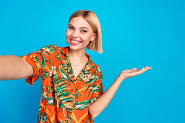 Poster - Photo of lovely cute girl wear trendy orange print clothes hold empty space isolated on blue color background