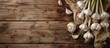 © StockKing - Garlic bulbs with long stalk on wooden table provide a rustic background for a copy space image.