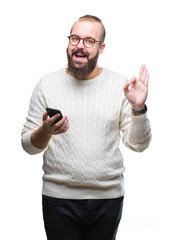 Sticker - Young caucasian hipster man texting sending message using smartphone over isolated background doing ok sign with fingers, excellent symbol