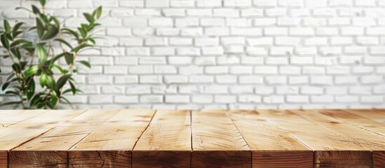 Wall Mural - Wooden table with no items atop and a blurry white brick wall in the background, suitable for product display or business presentations with copy space image.