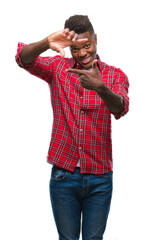 Wall Mural - Young african american man over isolated background smiling making frame with hands and fingers with happy face. Creativity and photography concept.