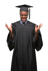 Wall Mural - Young graduated african american man over isolated background crazy and mad shouting and yelling with aggressive expression and arms raised. Frustration concept.