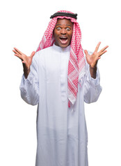 Canvas Print - Young arabic african man wearing traditional keffiyeh over isolated background celebrating crazy and amazed for success with arms raised and open eyes screaming excited. Winner concept