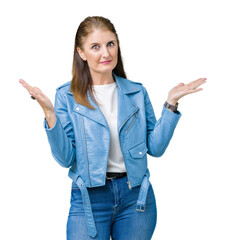 Wall Mural - Beautiful middle age mature woman wearing fashion leather jacket over isolated background clueless and confused expression with arms and hands raised. Doubt concept.