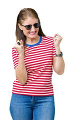 Canvas Print - Middle age mature woman wearing sunglasses over isolated background very happy and excited doing winner gesture with arms raised, smiling and screaming for success. Celebration concept.