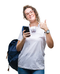 Sticker - Young brunette student girl wearing backpack, headphones and smartphone over isolated background happy with big smile doing ok sign, thumb up with fingers, excellent sign