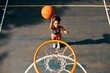 © Chanelle M/peopleimages.com - Practice like youve never won, play like youre never lost. High angle shot of a sporty young woman throwing a basketball into a net on a sports court.