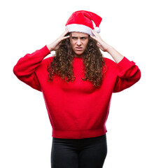 Sticker - Young brunette girl wearing christmas hat over isolated background suffering from headache desperate and stressed because pain and migraine. Hands on head.