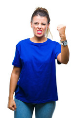 Canvas Print - Young beautiful woman wearing casual blue t-shirt over isolated background angry and mad raising fist frustrated and furious while shouting with anger. Rage and aggressive concept.