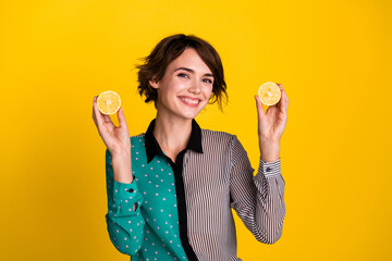 Sticker - Photo of charming cheerful nice woman wear stylish clothes hold two lemons isolated on yellow color background