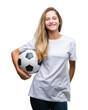 © Krakenimages.com - Young beautiful blonde woman holding soccer ball over isolated background with a happy face standing and smiling with a confident smile showing teeth