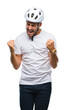 © Krakenimages.com - Young handsome man wearing cyclist safety helmet over isolated background very happy and excited doing winner gesture with arms raised, smiling and screaming for success. Celebration concept.