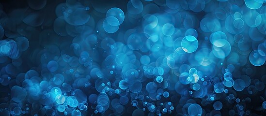 Wall Mural - A blue blurred bokeh effect against a black backdrop creating shining circles as a wallpaper with an area for text on the image. with copy space image. Place for adding text or design