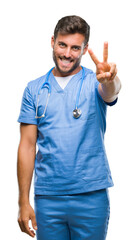 Wall Mural - Young handsome doctor surgeon man over isolated background smiling looking to the camera showing fingers doing victory sign. Number two.