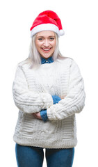 Canvas Print - Young blonde woman wearing christmas hat over isolated background happy face smiling with crossed arms looking at the camera. Positive person.