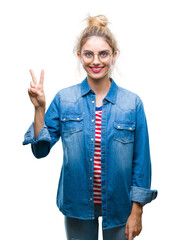 Canvas Print - Young beautiful blonde woman wearing glasses over isolated background showing and pointing up with fingers number two while smiling confident and happy.