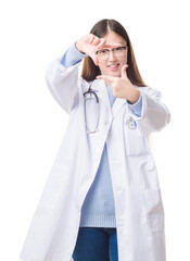 Wall Mural - Young Chinese doctor woman over isolated background smiling making frame with hands and fingers with happy face. Creativity and photography concept.