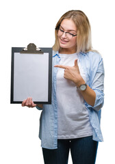 Poster - Young caucasian business woman holding clipboard over isolated background very happy pointing with hand and finger