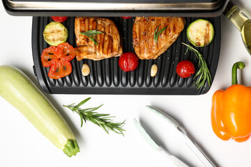 Wall Mural - Electric grill with tasty meat, spices and vegetables on white table, flat lay