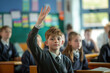 © Alexandra - Smart schoolboy raising hand to answer a question during a lesson in a classroom