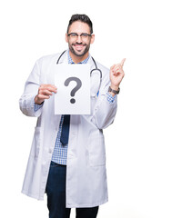 Poster - Handsome young doctor man holding paper with question mark over isolated background very happy pointing with hand and finger to the side