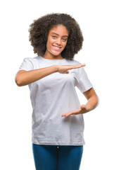 Poster - Young afro american woman over isolated background gesturing with hands showing big and large size sign, measure symbol. Smiling looking at the camera. Measuring concept.