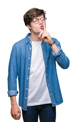 Sticker - Young handsome man wearing glasses over isolated background asking to be quiet with finger on lips. Silence and secret concept.