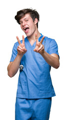 Sticker - Young doctor wearing medical uniform over isolated background smiling looking to the camera showing fingers doing victory sign. Number two.