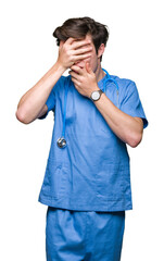 Sticker - Young doctor wearing medical uniform over isolated background Covering eyes and mouth with hands, surprised and shocked. Hiding emotion