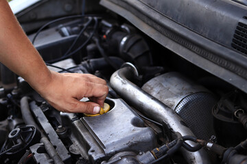 close-up of a diesel engine oil filler cap. the man's hand checks whether the oil filler cap is tigh