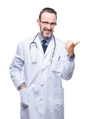 Wall Mural - Middle age senior hoary doctor man wearing medical uniform isolated background smiling with happy face looking and pointing to the side with thumb up.