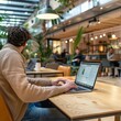 © Danko - Young man using laptop in a cafeteria