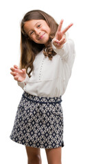 Wall Mural - Brunette hispanic girl smiling looking to the camera showing fingers doing victory sign. Number two.