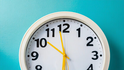 Part of white wall clock with yellow second hand hanging on wall. Close up image of plastic wall clock over turquiose blue background with copy space. Photo of time management or time is going concept