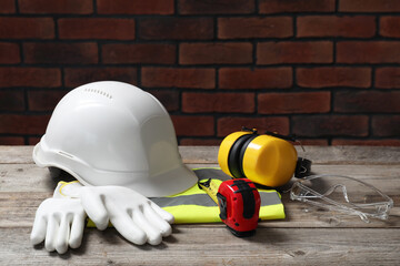 Wall Mural - White hard hat and other personal protective equipment on wooden surface