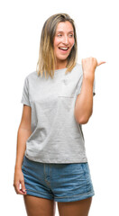 Wall Mural - Young beautiful woman over isolated background smiling with happy face looking and pointing to the side with thumb up.