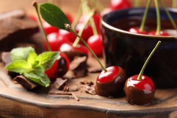 Wall Mural - Fresh cherries with melted chocolate and mint on table, closeup