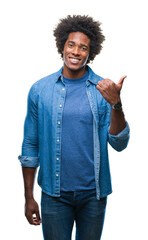 Sticker - Afro american man over isolated background smiling with happy face looking and pointing to the side with thumb up.