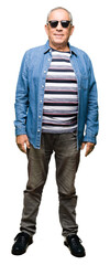 Canvas Print - Handsome senior man wearing denim jacket and sunglasses with a happy and cool smile on face. Lucky person.