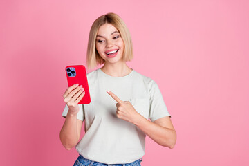 Sticker - Photo of impressed overjoyed woman with bob hairdo dressed t-shirt indicating look at smartphone isolated on pink color background